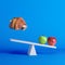 Apples sitting on seesaw with floating pork leg on opposite end on blue background