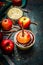 Apples on sticks with chocolate coating and twigs on rustic wooden background