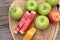 Apples and watermelon delicious on wood background.