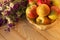 Apples in a woven vase with meadow flowers on a wooden table