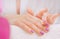 Application of cream on female hands with purple nail