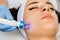 Application of microcurrent massage device on female face