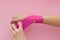 Appling a kinesio tape to hand  on pink background. Physiotherapy tape for wrist pain, aches and tension