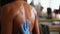 Applying body oil on female bodybuilder back. Getting ready for bodybuilding championship.