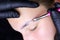 Applying compositions for laminating eyebrows to the hairs with a pink brush