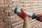 Applying grout with a syringe. Grouting decorative tile with white cement grout.