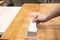 Applying protective painting varnish by hand on a wooden texture, diy and repair house equipment concept