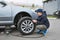 Apprentice auto mechanic changes the wheel of a car.  Auto repair concept