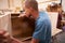 Apprentice Building Furniture In Carpentry Workshop