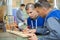 apprentice carpenter measuring wood for sawing