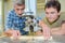 Apprentice carpenter watching how to use bench saw