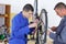 Apprentice fixing bike wheel in store