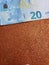 approach to euro bill of 20 euro and background in metallic copper color