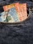 approach to front pocket of jeans in blue with Costa Rican banknotes