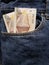 approach to front pocket of jeans in blue with peruvian banknotes
