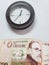 approach to uruguayan banknote of 200 pesos and background with a circular wall clock