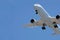 Approaching plane with its landing gear out against a blue sky near Los Angeles airport