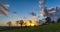 An approaching rainstorm is beautifully lit by the sun slowly setting over the rolling countryside near Montpinchon in Normandie,