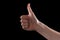 Approval thumbs up like sign as caucasian hand gesture isolated over black