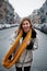 Ð appy pretty European girl with fashionable yellow scarf is laughing on cold city street