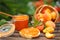 Apricot jam in a glass jar, fresh apricots in a basket on wooden background