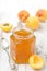 Apricot marmalade in a glass jar and fresh apricots