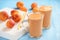 Apricot smoothie, healthy beverage, on wooden background.