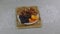 Apricots, prunes, dates, walnuts on a white saucer standing on a bamboo napkin.