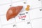 The April 19th calendar and liver human artificial with wooden push pin. World Liver Day Concepts