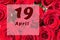 April 19th. Day of 19 month, calendar date. Natural background of red roses. A bouquet of dark red roses