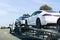 April 26, 2019 Redwood City / CA / USA - Car transporter carries Tesla Model 3 new vehicles along a highway in San Francisco bay