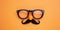 April Fools Day Disguise Topdown View Of Glasses, Fake Nose, And Mustache On Orange Backdrop