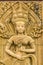 An Apsara dancing carved on the sandstone wall background. Apsara is a female spirit of the clouds and waters in Hindu culture. He