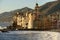 apse of Assunta church on white froth of rough sea, Camogli, Italy