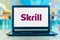 Aptop computer displaying logo of Skrill