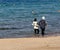 Aqaba, Jordan, March 8, 2018: Two fully clothed Muslim ladies wading through the shallow waters of the Gulf of Aqaba next to the b