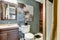 Aqua tone bathroom with brown cabinet and mirror