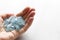 Aquamarine stone lies in the hand. Natural stone Aquamarine on a white background. Female hand. Copy space for your text