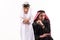 Arab adult man in keffiyeh in quarrel with son.