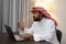 an Arab businessman wearing a turban during a teleconference meeting using a laptop