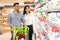 Arab Couple Shopping Groceries Walking Along Shelves In Supermarket