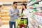 Arab Customers Couple Shopping Groceries Choosing Dairy Products In Supermarket