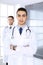 Arab doctor man standing with caucasian colleague in medical office or clinic. Diverse doctors team, medicine and