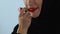 Arab female in hijab doing bright make-up, applying red lipstick, beauty concept