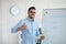 Arab male teacher showing thumb up near blackboard, teaching English on web, recommending online foreign language school