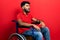 Arab man with beard sitting on wheelchair angry and mad screaming frustrated and furious, shouting with anger