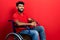 Arab man with beard sitting on wheelchair with a happy and cool smile on face