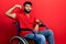 Arab man with beard sitting on wheelchair strong person showing arm muscle, confident and proud of power