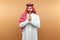 Arab man businessman in national clothes folded his hands in prayer, like, beige background. Dishdasha, kandora, thobe, middle