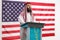 Arab man giving a speech on a pedestal in front of USA flag